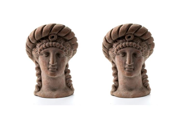 Coppia di antefisse in terracotta rappresentanti teste muliebri