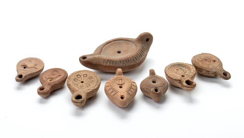 Lotto di 8 lucerne in terracotta con decori a rilievo rappresentanti guerriero, due lucertole con...