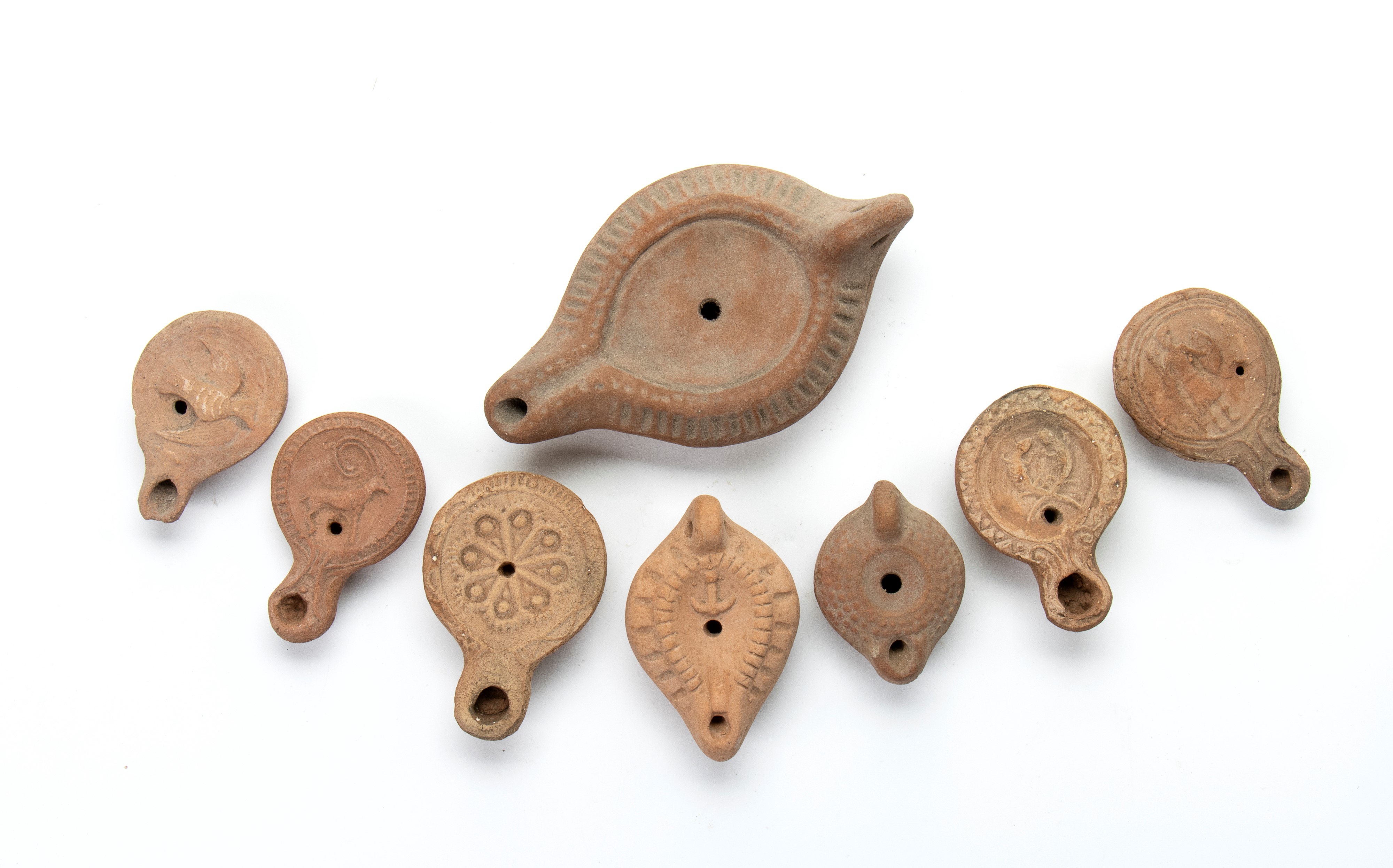 Lotto di 8 lucerne in terracotta con decori a rilievo rappresentanti guerriero, due lucertole con...