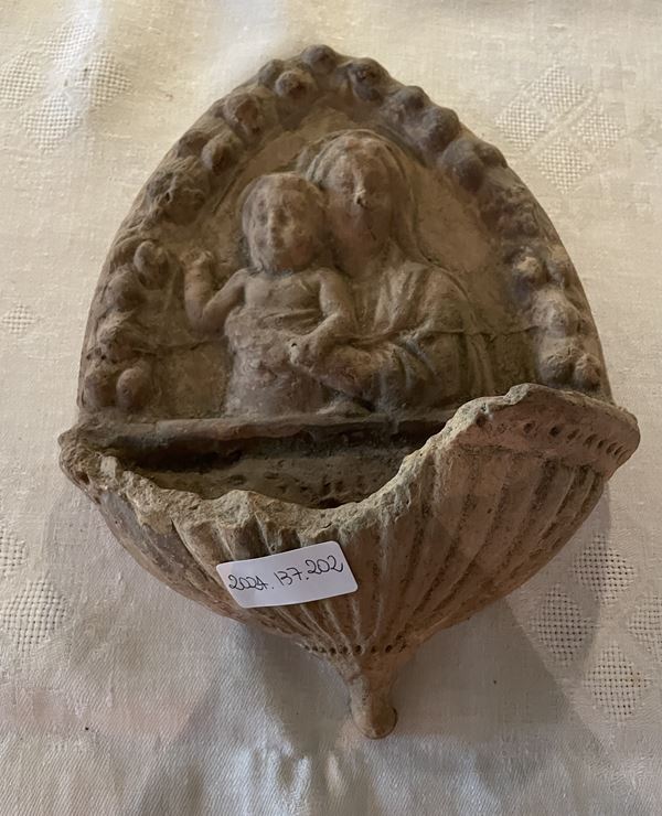 Frammento di acquasantiera raffigurante la Madonna con in braccio il Bambino in un serto ogivale di fiori.   (XX secolo)  - Asta Collezione Eredità Architetto Massimo Papiri  - Gliubich Casa d'Aste