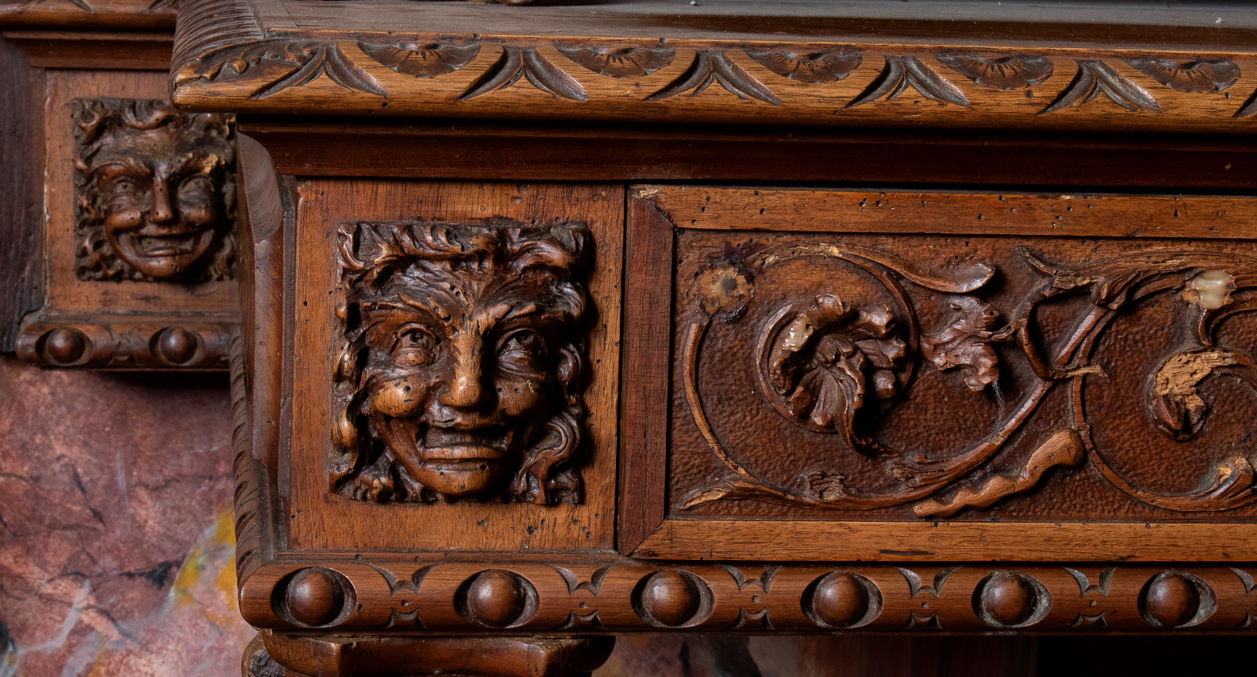 Consolle da parete in noce con ricca decorazione a racemi sul cassetto frontale. Mascheroni agli ...