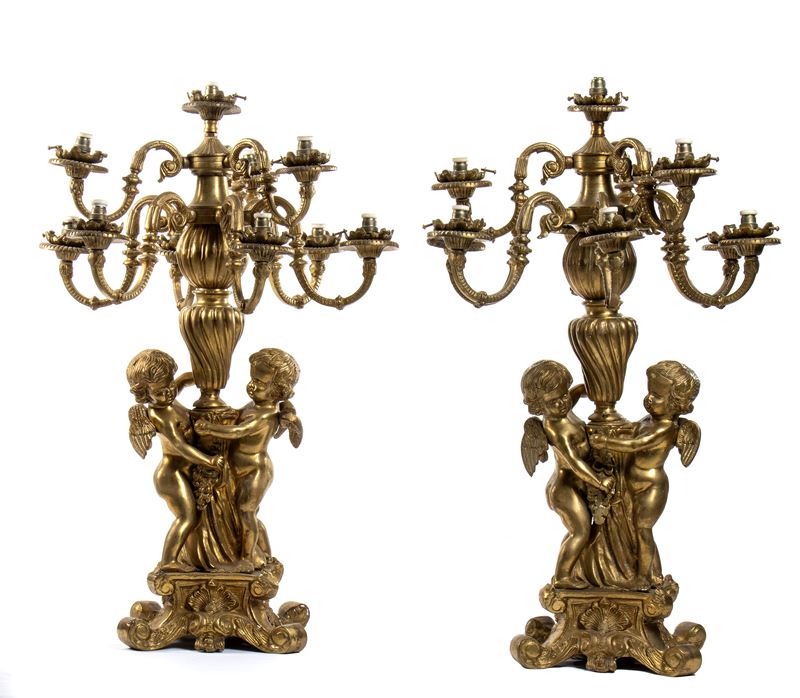 Coppia di candelieri a 9 luci in bronzo dorato e finemente cesellato con putti stanti a trattener...