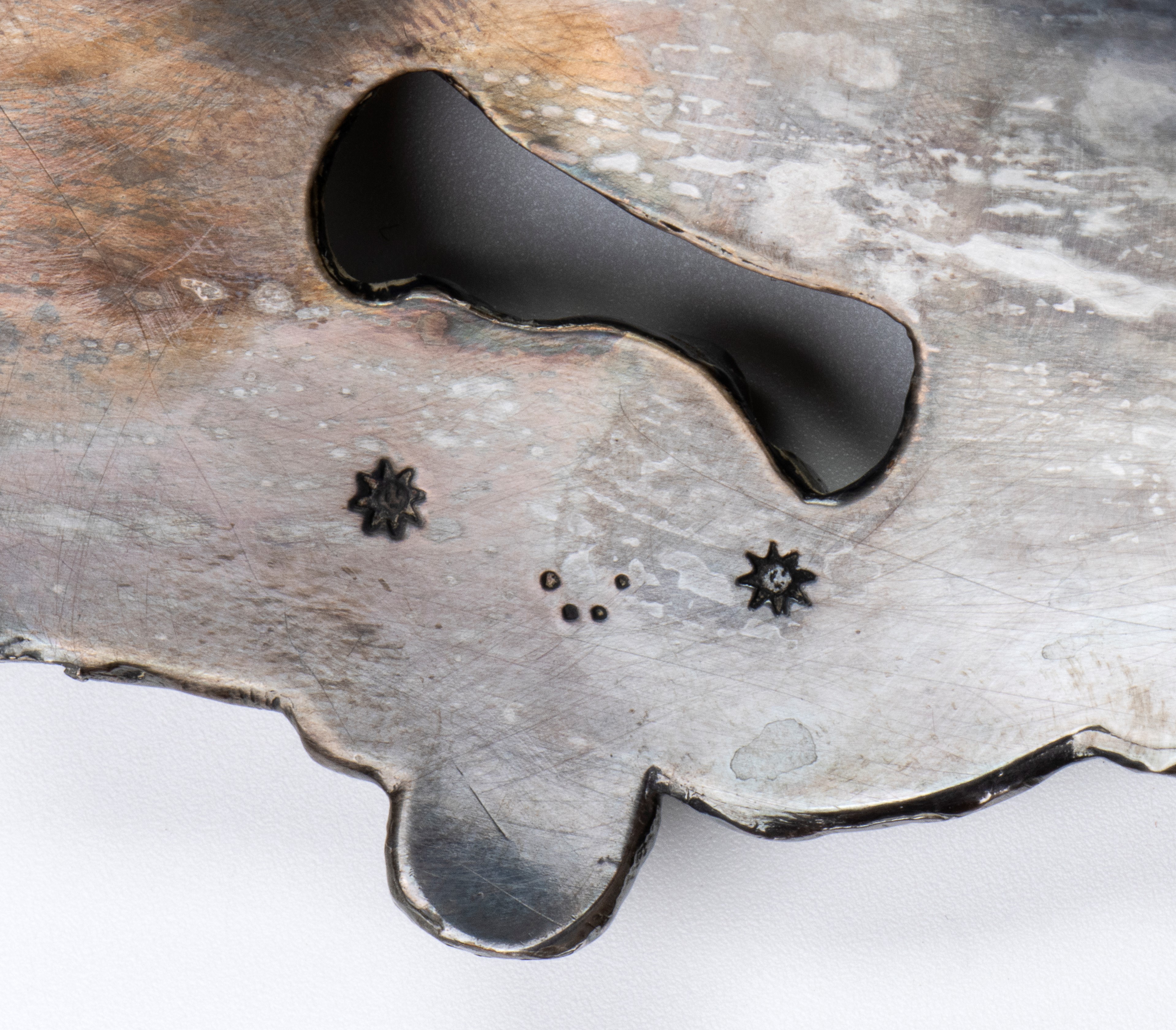 Grande vassoio rotondo in metallo argentato con bordi mistilinei e decoro fitomorfo a rilievo sul...