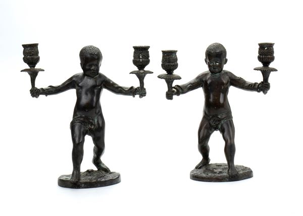 Coppia di piccoli candelabri con putti reggicandela in bronzo patinato nero