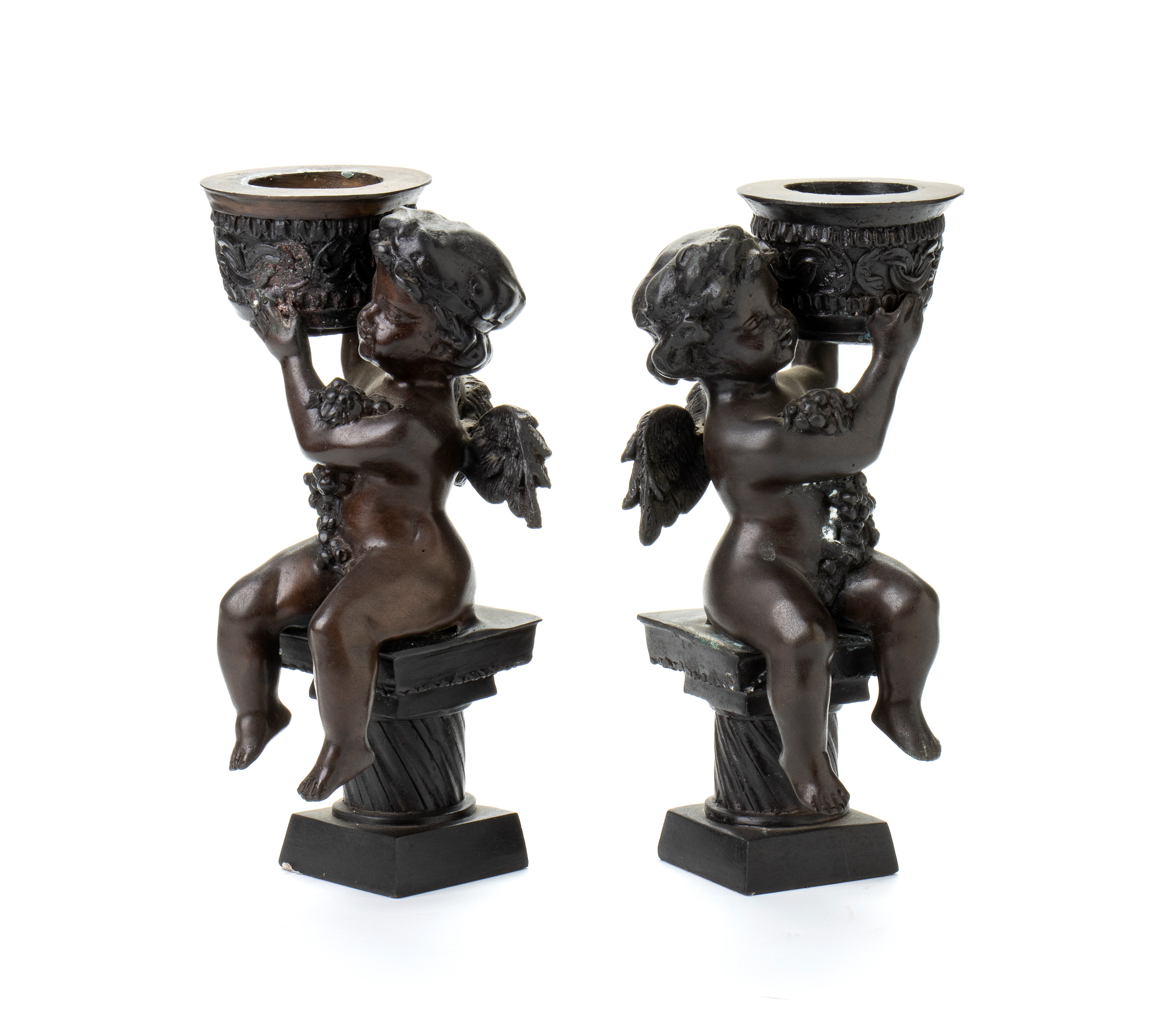 Coppia di reggicandela a forma di putti alati con cornucopie o serti di frutti