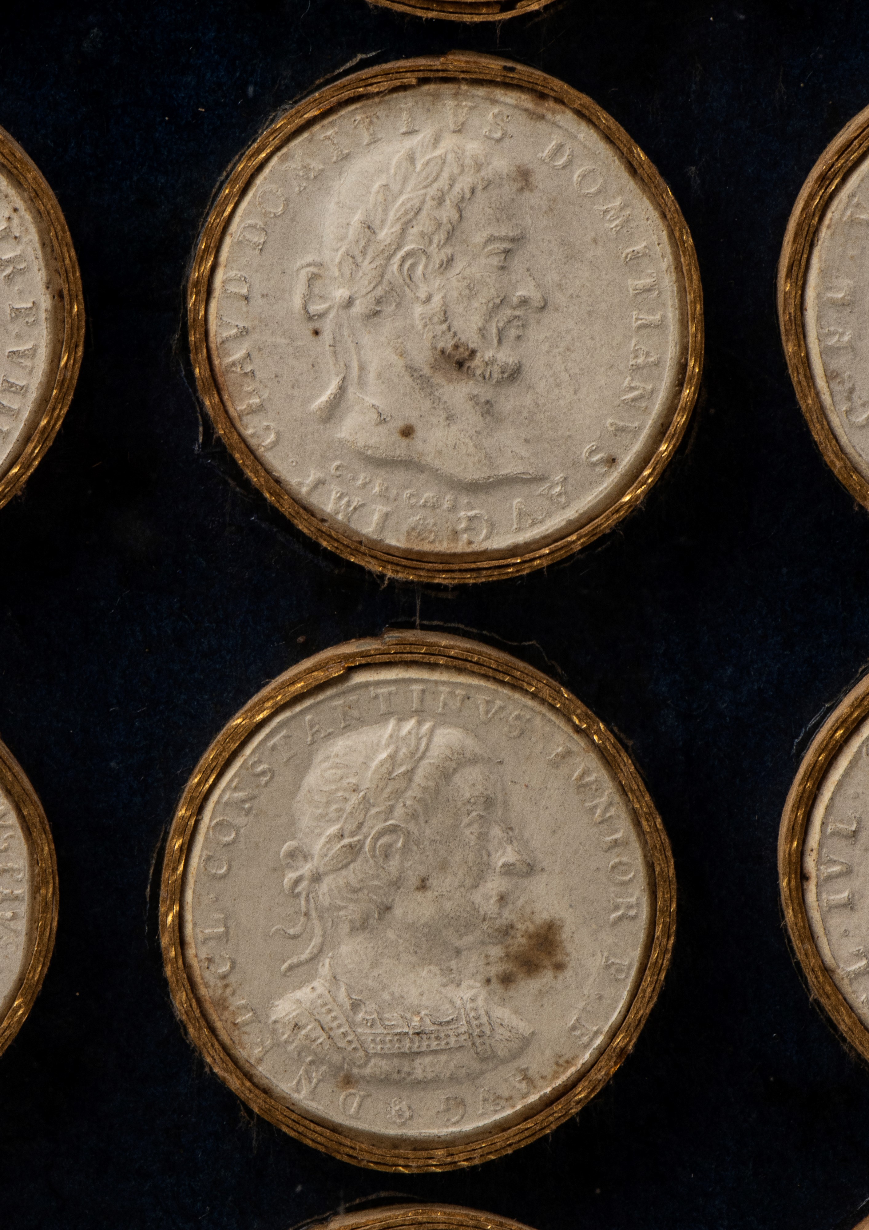 Teca in perspex laccato nero e trasparente conteneenti riproduzioni di antiche monete romane in g...