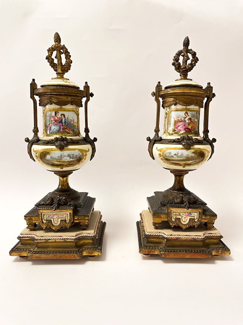 Set di due vasi in bronzo dorato finemente cesellato con inserti floreali. Corona d'alloro e pign...