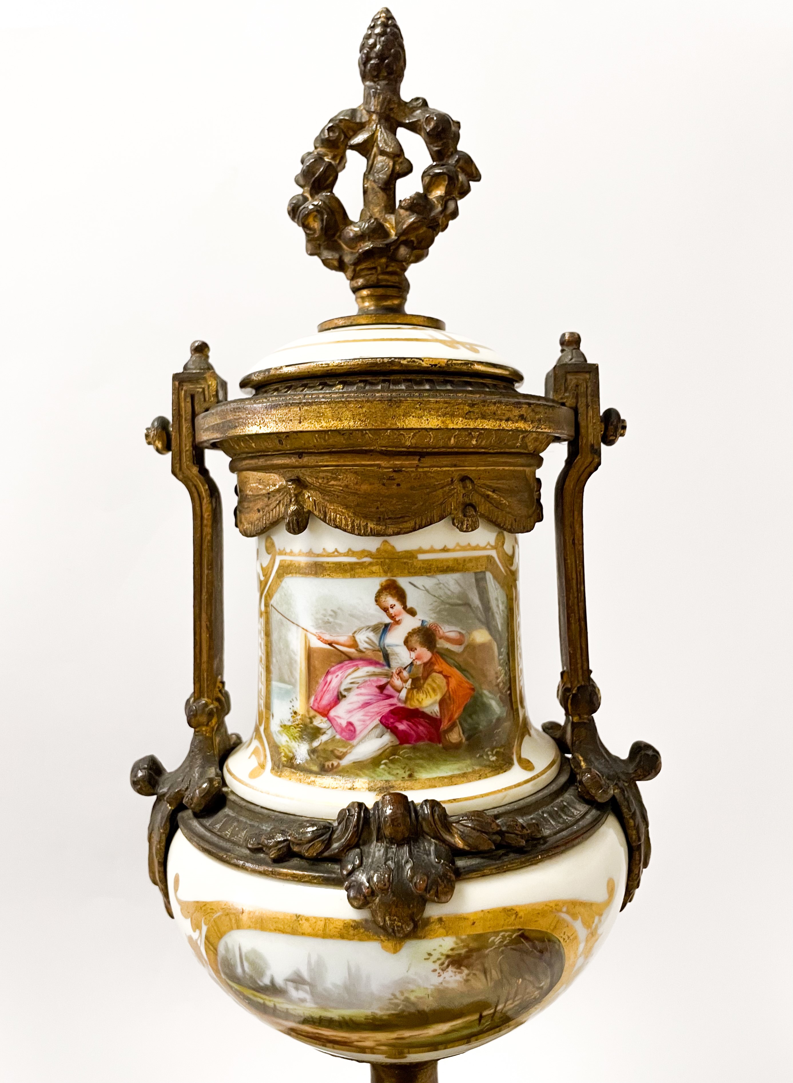 Set di due vasi in bronzo dorato finemente cesellato con inserti floreali. Corona d'alloro e pign...