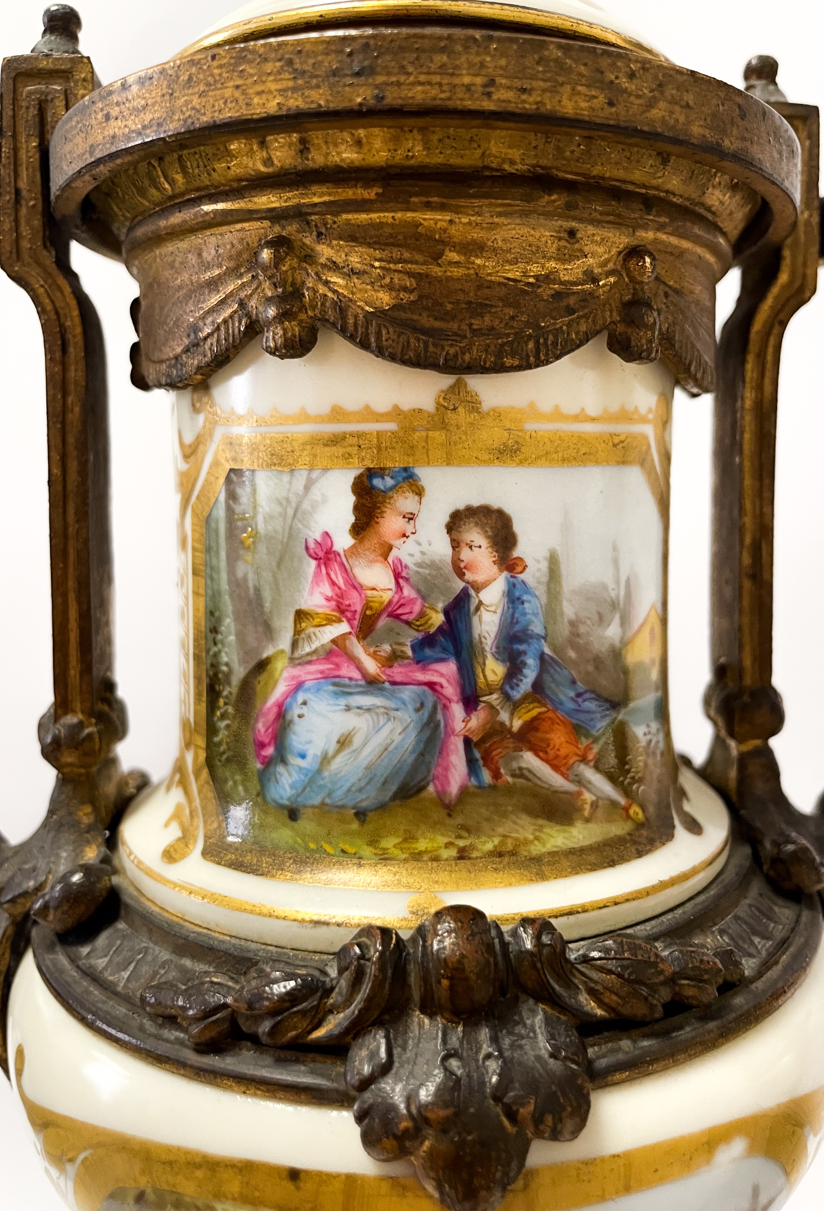 Set di due vasi in bronzo dorato finemente cesellato con inserti floreali. Corona d'alloro e pign...