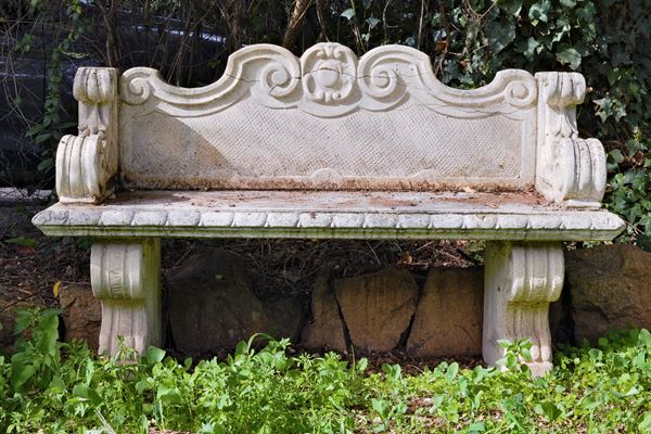 Coppia di panchine da giardino in polvere di cemento e marmo con schienale sagomato, braccioli e piedi a grandi volute