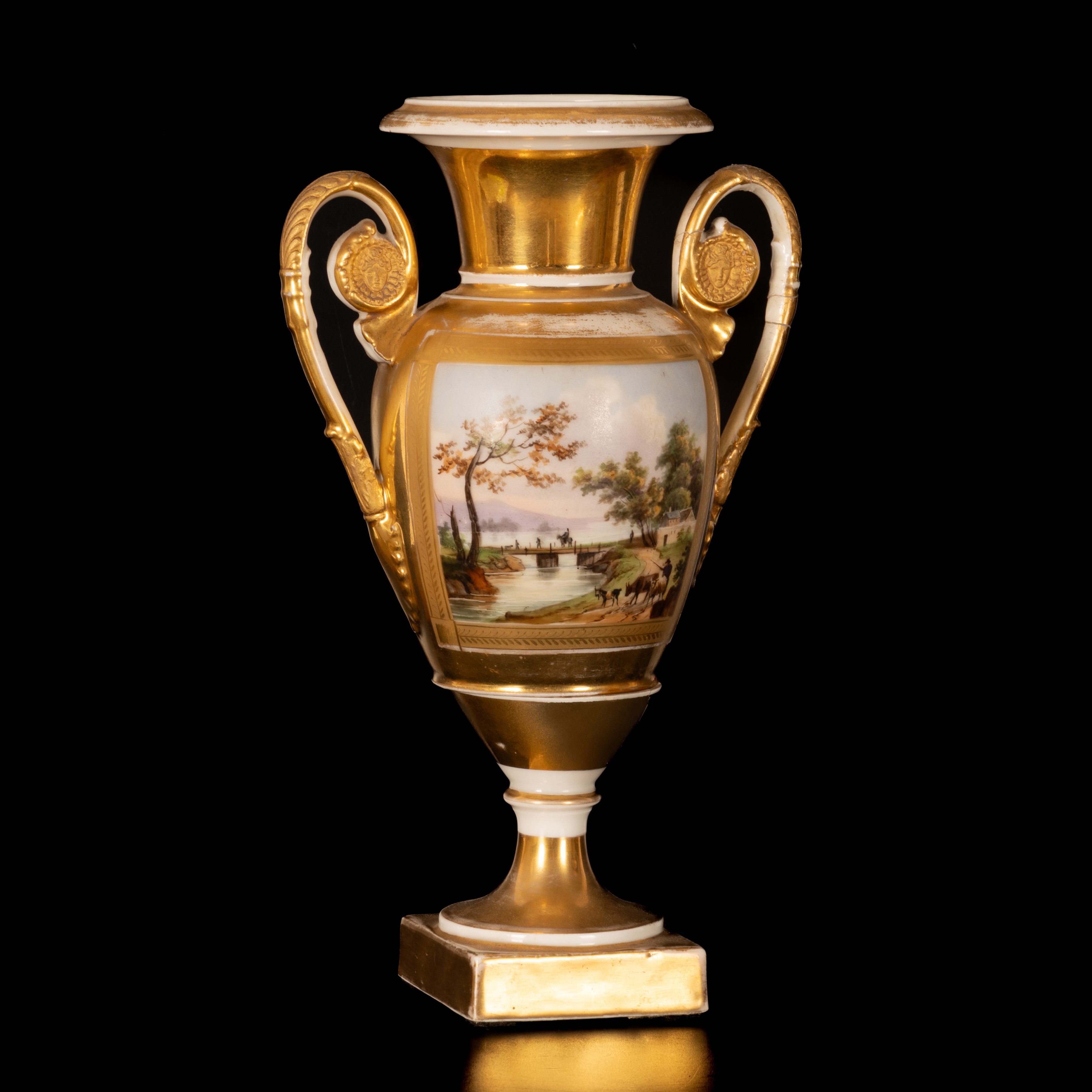 Vaso biansato in porcellana a fondo oro e decoro policromo di paesaggio agreste entro riserva cen...