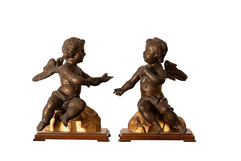 Coppia di piccoli putti in bronzo su basi in legno