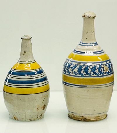 Manifattura di Bussi sul Tirino, Lotto di due bottiglie in maiolica con decorazioni concentriche