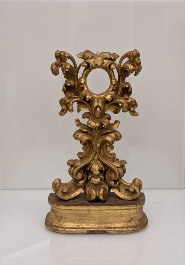 Manifattura Italiana della Fine del XVIII Secolo - Reliquiario a ostensorio in legno di bosso dorato e riccamente intagliato con girali fogliati e fiori, poggiante su una base