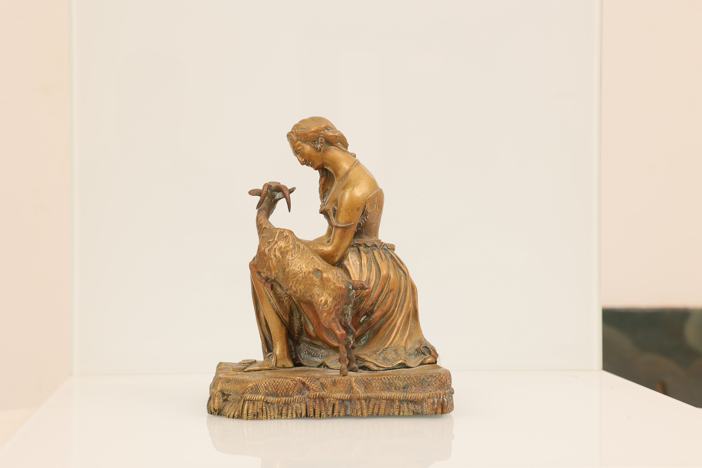 Coppia di sculture in bronzo dorato, raff. donne con animali