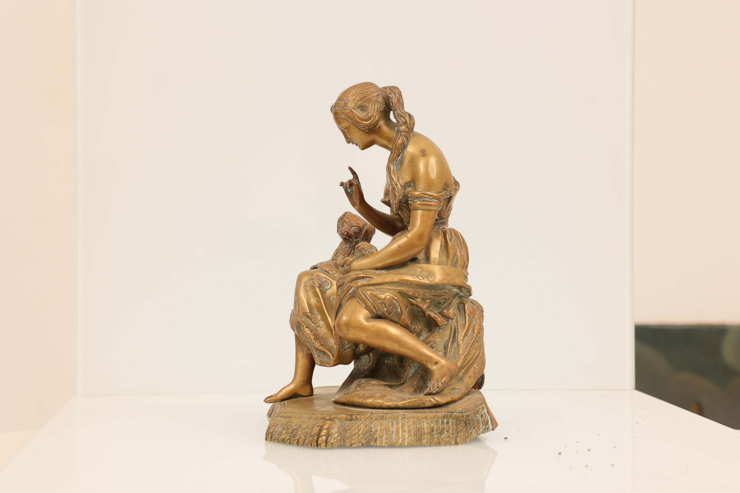 Coppia di sculture in bronzo dorato, raff. donne con animali
