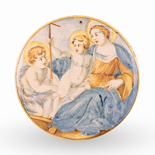 Manifattura castellana del XVIII secolo - Tondo in maiolica decorato in policromia con Madonna, Gesù Bambino e San Giovannino. Filettatura in giallo e manganese sul bordo.