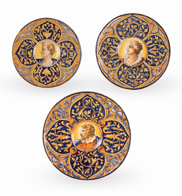 Manifattura di Pesaro del XIX secolo - Lotto di 3 piatti in maiolica decorati in policromia. Nel cavetto figure maschili e femminili su fondo arancio con motivo rocaille e bordi filettati in blu e giallo.