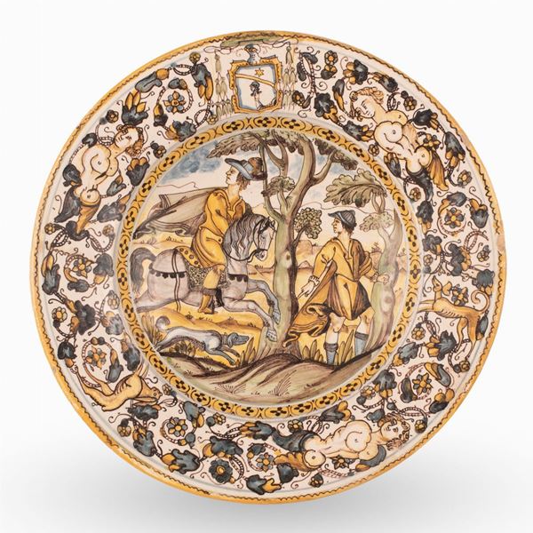 Francesco Angelo Grue - Piatto in maiolica policroma decorato nel cavetto con scena di caccia con cavaliere, servitore e cane in paesaggio alberato. Ispirato da un'incisione di Antonio Tempesta. 