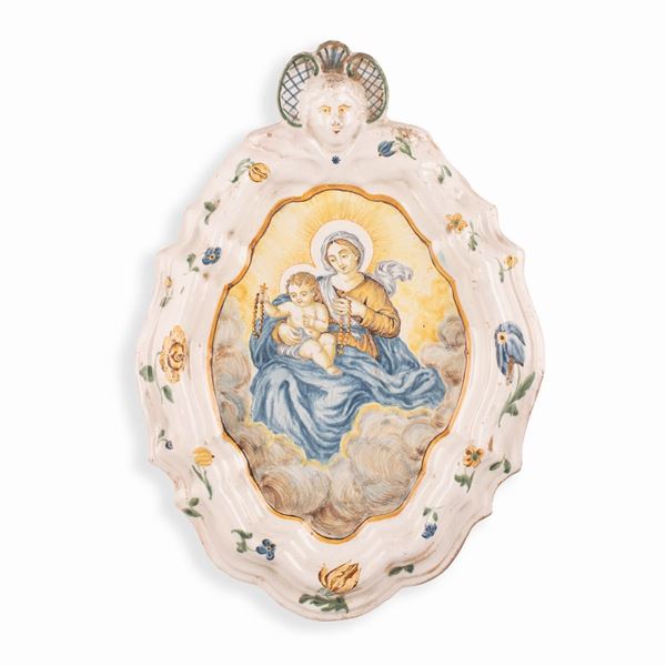 Manifattura castellana dell'ultimo quarto del XVIII secolo - Targa devozionale  in maiolica policroma raffigurante Madonna del Rosario con Gesù Bambino in cornice mistilinea sormontata. Probabilmente bottega di Silvio De Martinis o Gesualdo Fuina. 