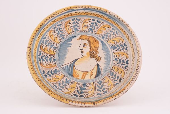 Manifattura di Bussi sul Tirino del XVII secolo - Alzata in maiolica decorata in policromia nello stile compendiario con al centro raffigurato un busto femminile.