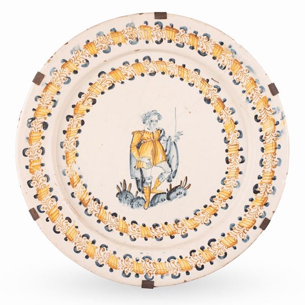 Manifattura castellana della seconda met&#224; del XVI secolo - Grande piatto compendiario in maiolica a gran fuoco con viandante entro doppia ghirlanda stilizzata