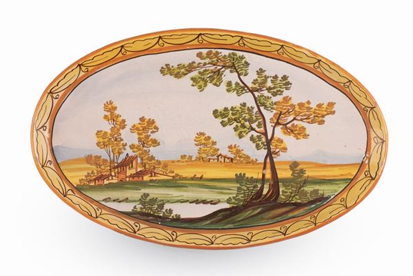 Manifattura castellana del XX secolo - Piatto ovale decorato in policromia con paesaggio, lago e case. Bordo festonato in giallo. 