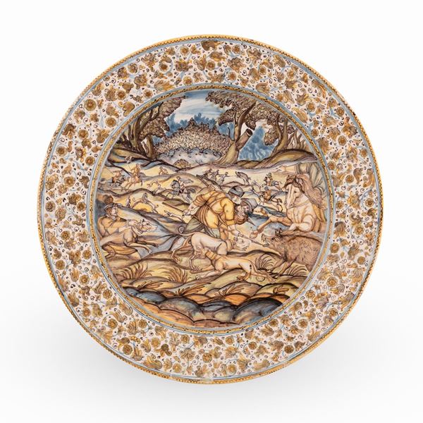 Francesco Angelo Grue - Piatto da "parata" decorato con minuti racemi fioriti sulla tesa e con scena venatoria nel cavo, tratta da antica incisione del Tempesta