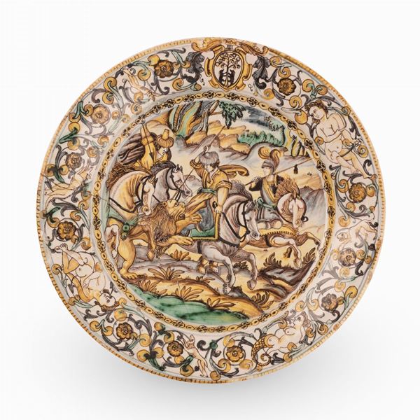 Francesco Angelo Grue - Piatto in maiolica decorato con girali fitomorfi, putti ed uno stemma sulla tesa e con scena di caccia al leone, nel cavo.