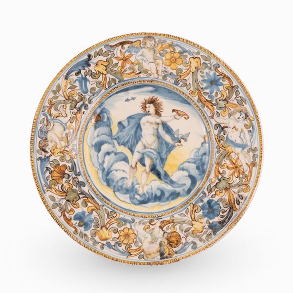 Francesco Angelo Grue - Castelli, bottega di Francesco Grue. Piatto in maiolica decorato con girali fogliati, fiori e putti sulla tesa e con scena mitologica nel cavo. 