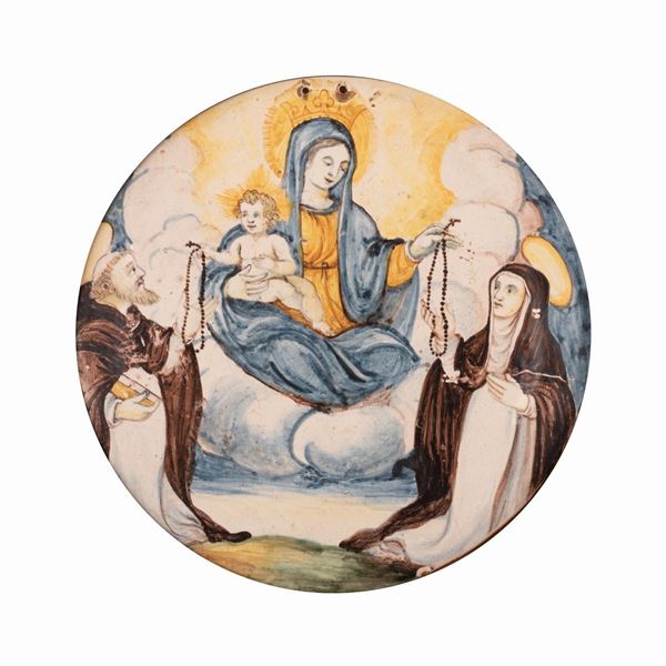 Maestro castellano attivo tra la fine del XVII ed il primo decennio del XVIII secolo - Tondo in maiolica raffigurante la Madonna del Rosario tra i Santi Domenico di Guzman e Caterina da Siena.