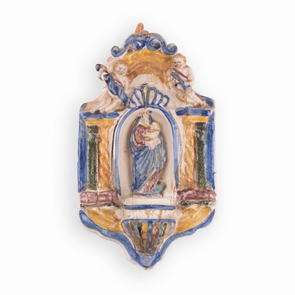 Manifattura castellana attiva tra la fine del XVIII e la prima met&#224; del XIX secolo - Acquasantiera in maiolica decorata con elementi a rilievo e con l'immagine della Madonna con il Bambino, nell'edicola centrale.