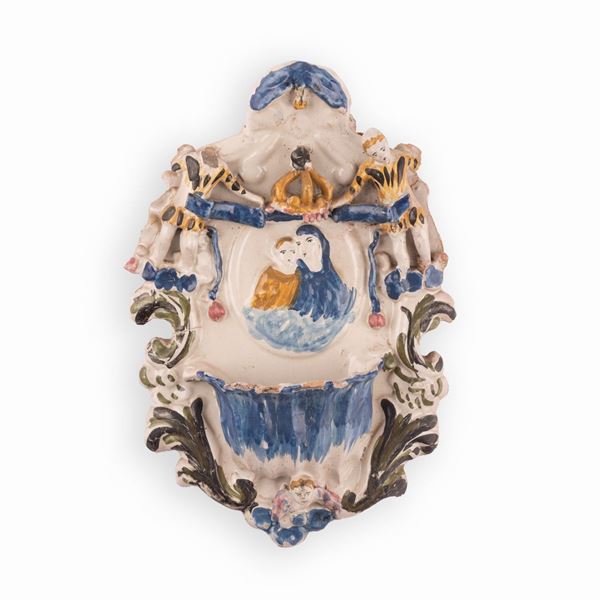 Manifattura faentina attiva nell'ultimo quarto del XVIII secolo - Acquasantiera in maiolica con decori a rilievo recante un medaglione centrale con l'effigie della Vergine con il Bambino.