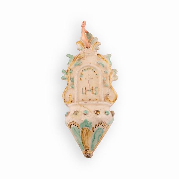 Manifattura dell'Italia centro-meridionale del XIX secolo - Acquasantiera in maiolica con decori in rilievo e monogramma cristologico HIS sormontato da una Croce.