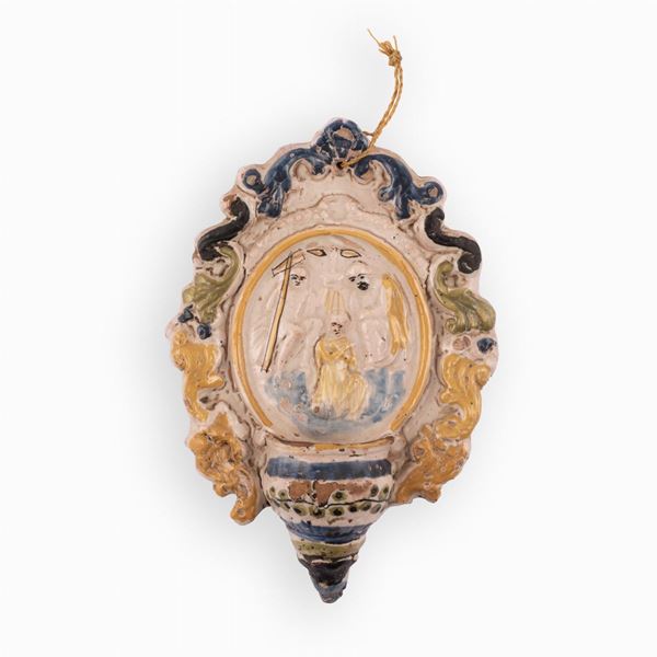Manifattura dell'Italia settentrionale del XIX secolo - Acquasantiera in maiolica con decori a rilievo centrati da un medaglione raffigurante la scena del Battesimo di Cristo