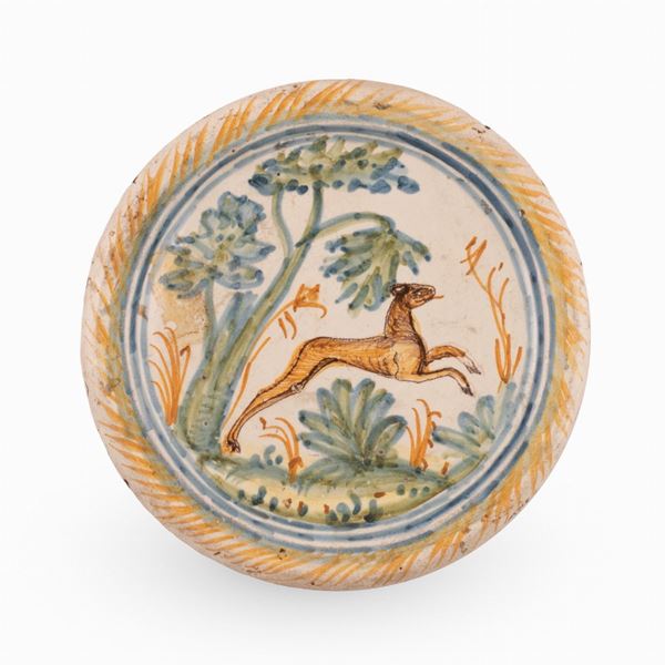 Manifattura dell'Italia meridionale attiva tra l'ultimo quarto del XVII ed il primo del XVIII secolo - Alzatina in maiolica decorata con animale stante in uno scorcio di paesaggio