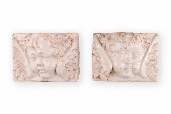 Manifattura toscana della fine del XVIII secolo inizio XIX secolo - Coppia di altorilievi in maiolica raffiguranti teste di angeli, probabilmente, tratti a calco da un'esemplare più antico in pietra.