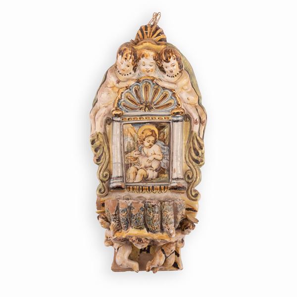 Manifattura castellana attiva nella seconda met&#224; del XVII secolo - Acquasantiera in maiolica decorata con elementi in rilievo e, nell'edicola centrale, con l'effige di San Giovannino