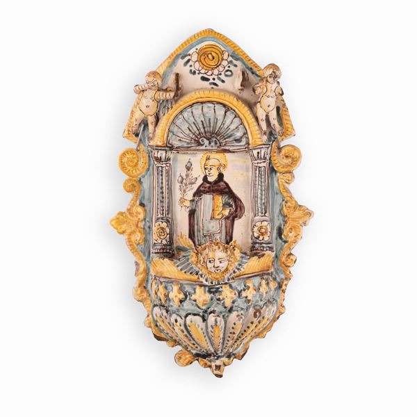 Manifattura castellana attiva nel terzo o quarto decennio del XVII secolo - Acquasantiera in maiolica decorata con elementi in rilievo e l'effigie di Sant'Antonio da Padova.