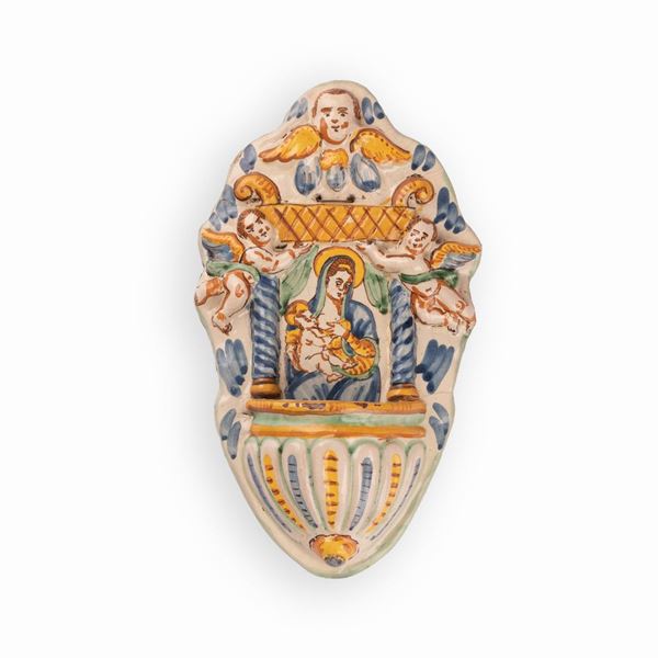 Manifattura di Cerreto Sannita attiva nel XVIII secolo - Acquasantiera in maiolica decorata con elementi a rilievo e con l'effigie della Madonna con il Bambino nell'edicola centrale
