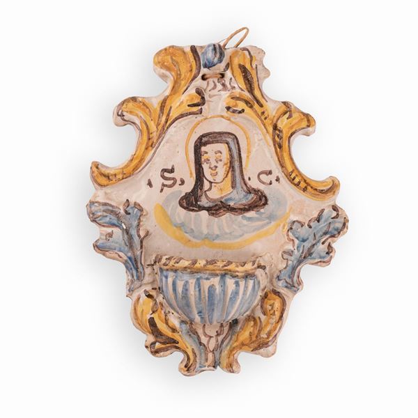 Manifattura castellana attiva tra la fine del XVIII e la prima met&#224; del XIX secolo - Acquasantiera in maiolica decorata con elementi a rilievo e dall'effigie di una Santa affiancata dalle lettere: "S" e "C"