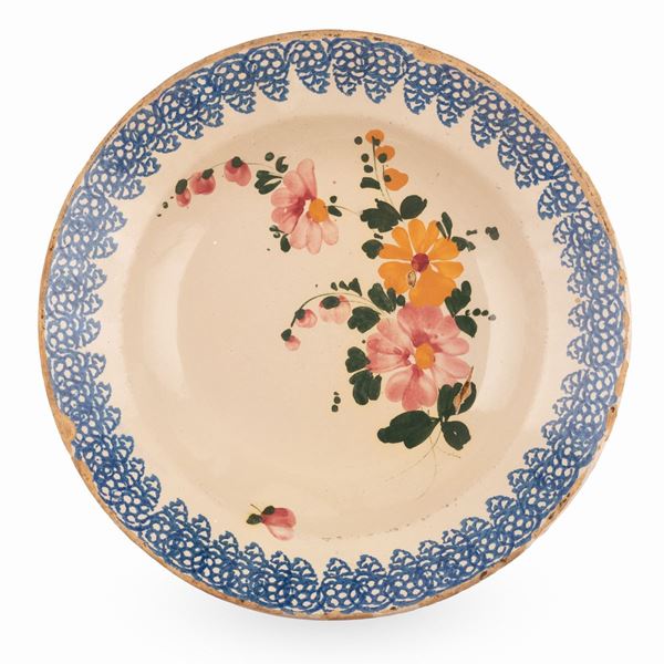 Manifattura abruzzese attiva tra il tardo XIX ed i primi del  XX secolo. - Grande piatto in maiolica  decorato, sulla tesa, con motivi a stampo