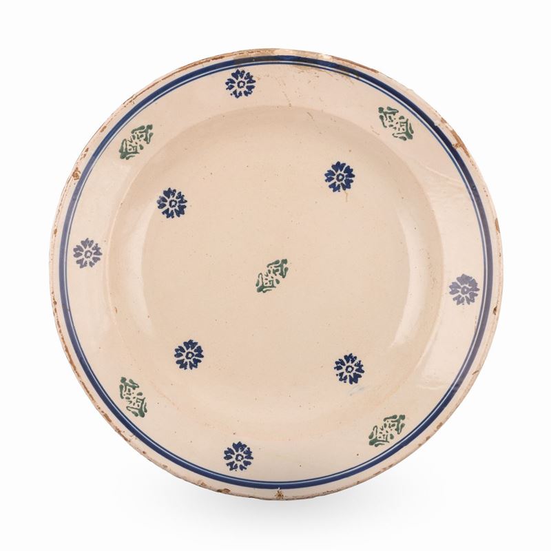 Grande piatto in maiolica decorato con motivi floreali stilizzati realizzati a stampo