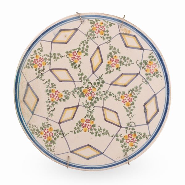 Manifattura abruzzese del XX secolo - Tagliere in maiolica decorato con elementi geometrici e floreali