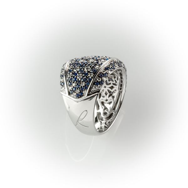 Anello a fascia realizzato in oro bianco con pavè misto di diamanti bianchi taglio brillante e zaffiri blu