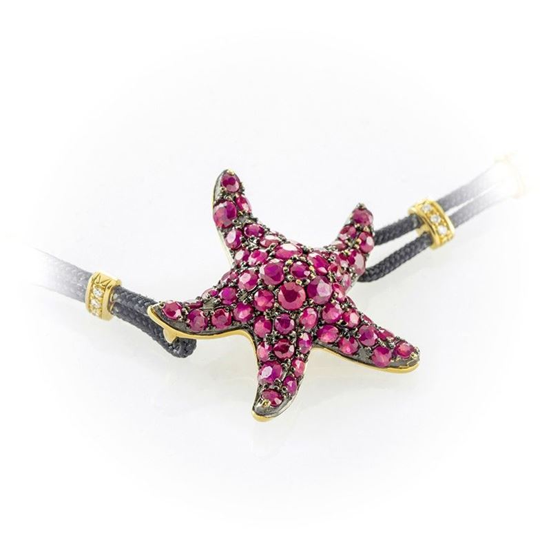 Bracciale in Cordino Nero con Stella Marina Impreziosita da Pavè di Rubini. Quattro Inserti in Or...