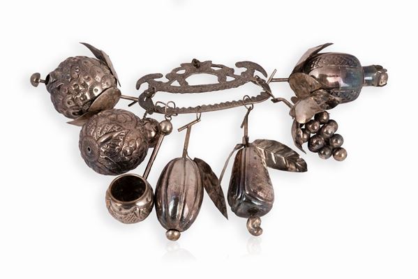 Elemento decorativo in metallo argentato composto da 7 frutti sostenuti da un manico cesellato con due pappagalli