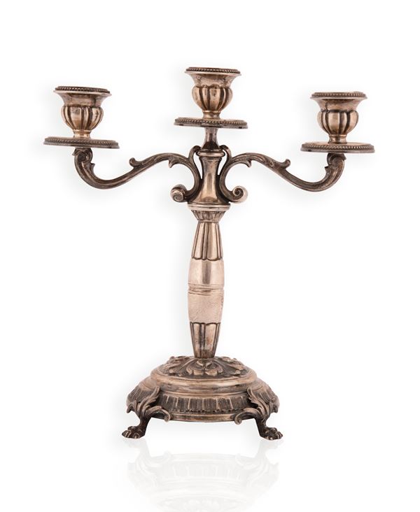 Candelabro in argento a tre luci cesellato con volute vegetali 