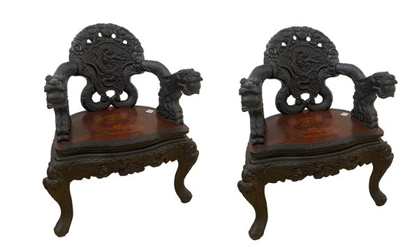Coppia di troni in legno ebanizzato. Braccioli, schienale e gambe realizzate con particolare intaglio di gusto orientale. 