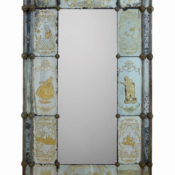 Antica specchiera di Murano decorata con elementi floreale a rilievo e scene veneziane incise e dorate. 